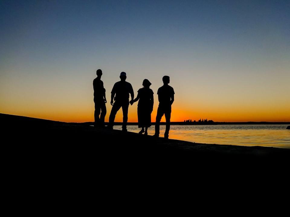 A family standing together at sunset